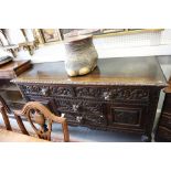 An early 20th century carved oak sideboard, fitted two short drawers over two central drawers,