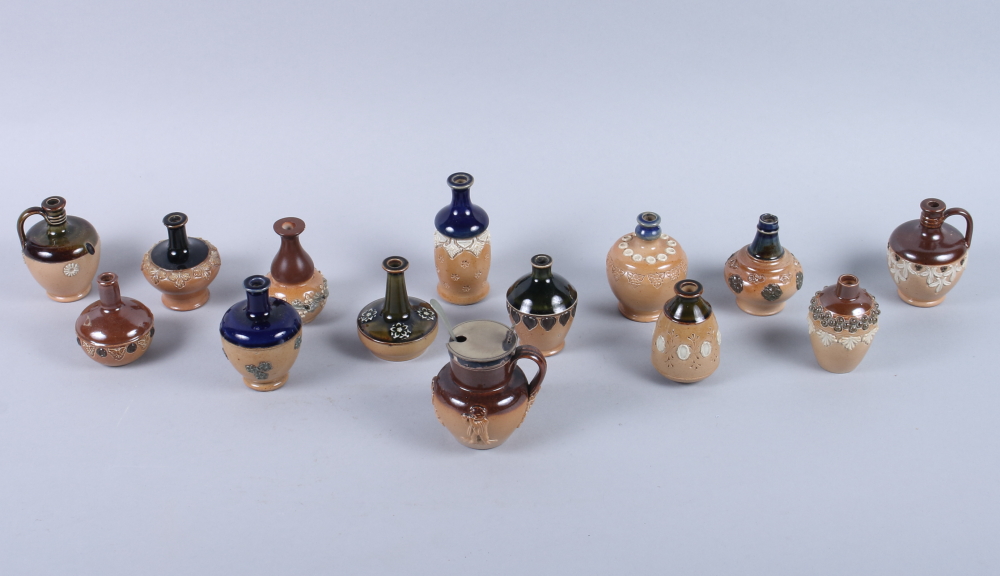 A collection of twelve Doulton Lambeth miniature stoneware sprig decorated vases, various designs,