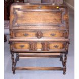 An oak fall front bureau with fitted interior, on turned and stretchered supports, 34" wide