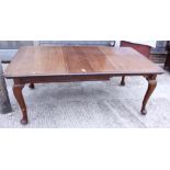 A walnut extending dining table with two extra leaves, on cabriole supports, top 72" x 42" when