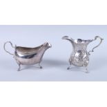 A George III silver sauce boat, 5.2oz troy approx, together with a white metal cream jug of Georgian