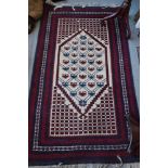 A Persian rug with all over lattice design on a white ground, multi bordered in shades of blue and