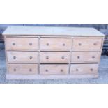 A stripped pine chest of nine drawers, 65" wide