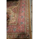 A Persian design rug with all over floral design in shades of pink, green and natural, 124" x 108"