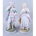 A pair of early 20th century French bisque porcelain figures of a standing male and female, 14"