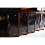 A mahogany bookcase enclosed central lattice glazed door and two plain doors, on bracket feet, 62"