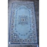 A Chinese contour pile rug with central floral medallion on a light green ground, 61" x 30" approx