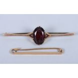 A 15ct gold tie pin and a 9ct gold and red stone brooch