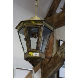 A brass framed ceiling lantern and two oil lamps with chimneys