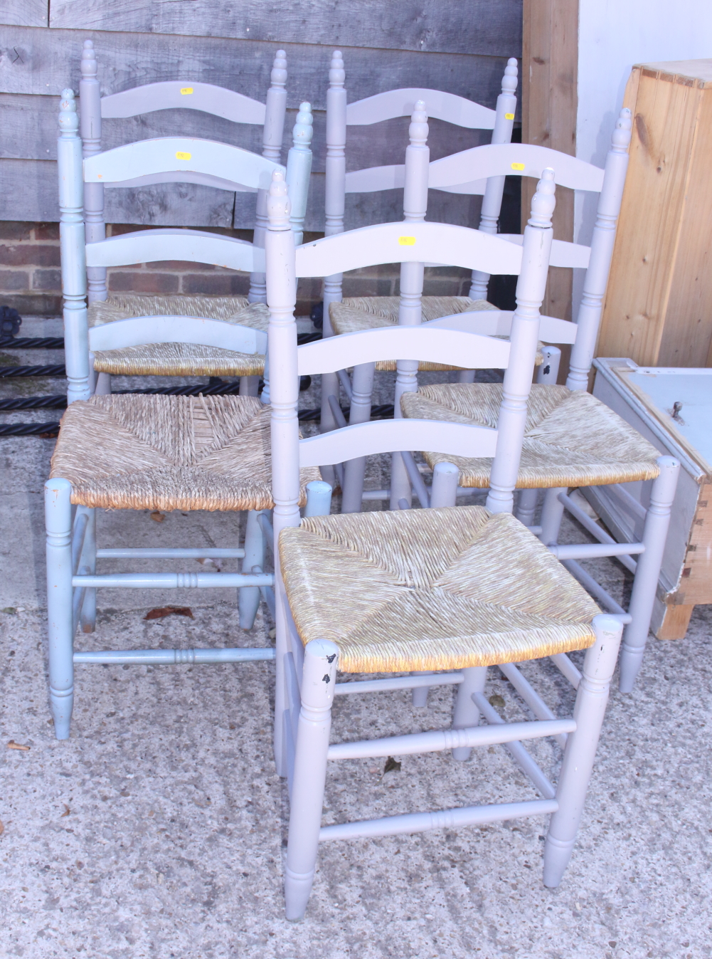 A set of five painted pine ladder back chairs with rush envelope seats