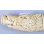A 17th century carved ivory ceremonial hunting horn with wild boar head mouth piece and hunting