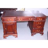 A Victorian style polished as mahogany partners desk, fitted drawers and cupboards, on bracket