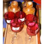 A set of six cranberry wine glasses, a Schweppes stoneware lemonade bottle and another similar