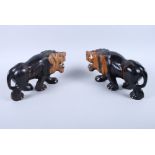 A pair of 20th century carved lignum vitae lions, with bone claws and teeth, 8 1/4" long