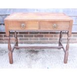 A 1930s oak desk with tooled lined top, fitted two drawers, on turned and stretchered supports,