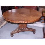 A mid 19th century mahogany circular tilt top dining table, on triform base with gadroon scrolls,