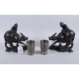 A pair of Chinese carved hardwood and white metal line inlaid water buffalo with figures on backs, 8