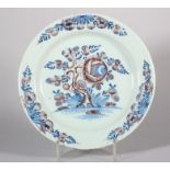 An 18th century English delft plate with peony decoration in manganese and blue, 8 7/8" dia (hair