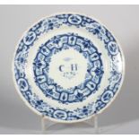 An early 18th century Bristol delft plate with swag and scroll decoration, inscribed monogram "