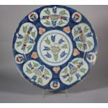 An 18th century Bristol delft charger with central floral panel and reserved panels of flowers on