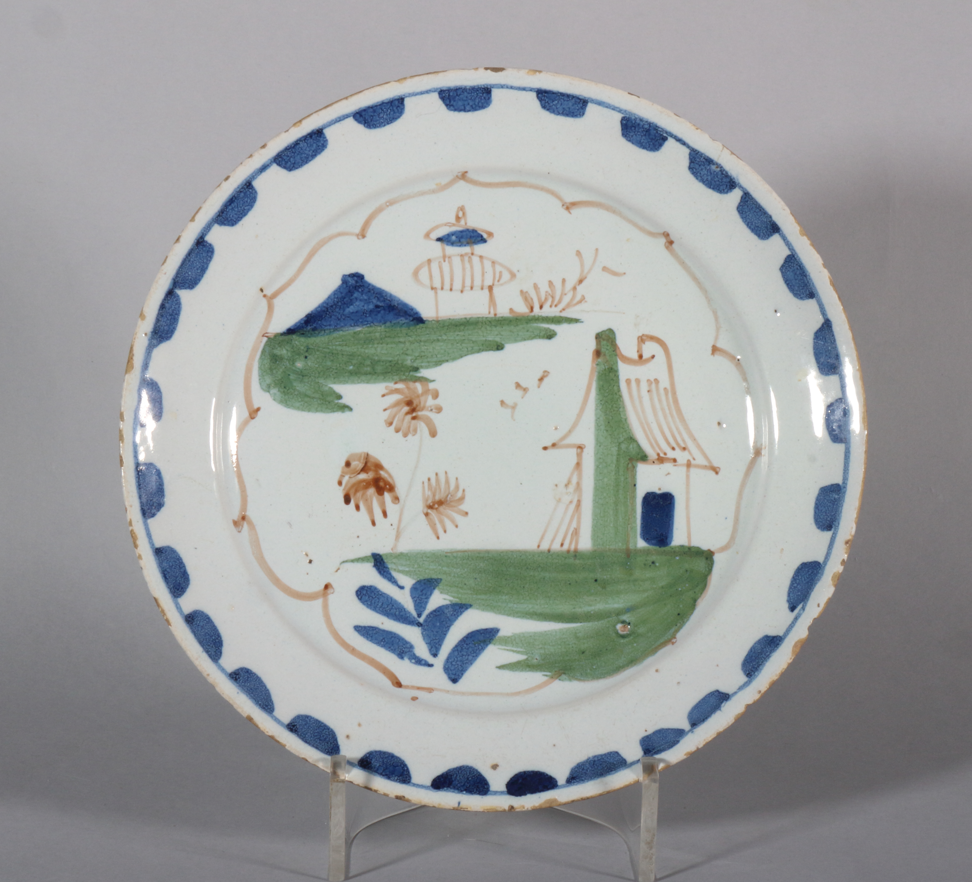 An 18th century Lambeth delft plate with simple landscape and blue dash border, 8 3/4" dia, 1740