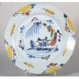 An 18th century English delft plate with polychrome landscape centre and border decoration, 8 7/8"