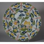An 18th century London delft charger with trees, flowers and fence decoration, 13 5/8" dia (