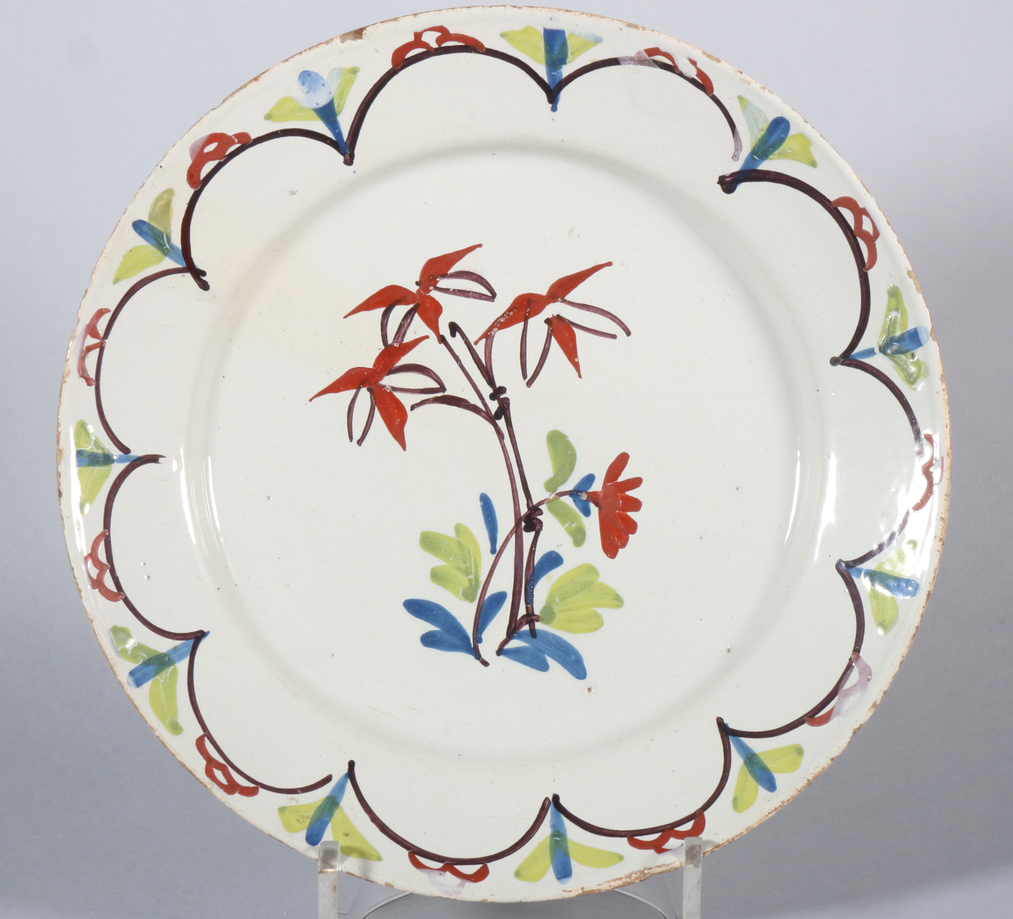 An 18th century English delft plate with polychrome bamboo centre, 8 7/8" dia (stabilised crack)