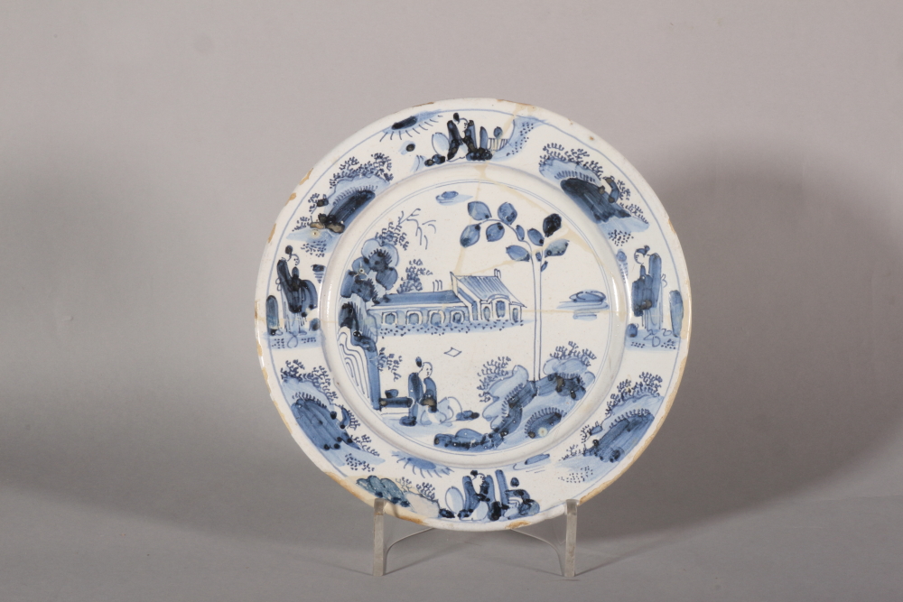 An 17th century London delft plate with chinoiserie landscape with seated figure decoration,