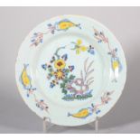 An 18th century English delft plate with polychrome rock and flower decoration and "fish" border,