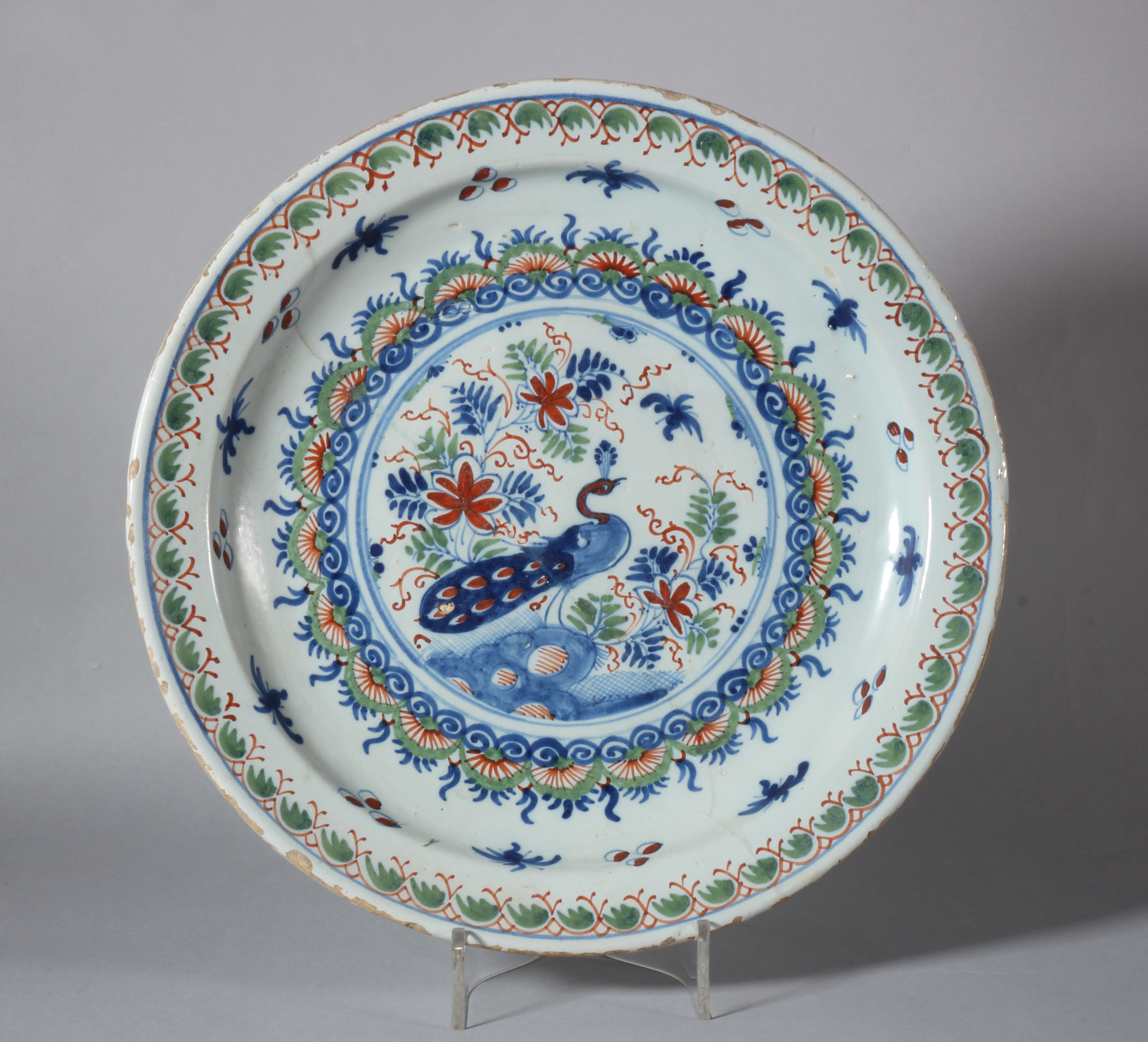 An 18th century Bristol? delft charger with peacock decoration, foot rim with two holes, 13" dia (