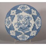 An 18th century Liverpool delft plate with chinoiserie reserved panel decoration of vase and table
