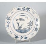 An 18th century English delft plate with landscape centre and insect and flower border, 9" dia (
