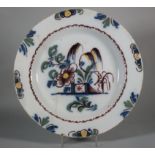 An 18th century Liverpool delft charger with fence and trees decoration and floral border, 14"