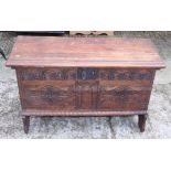 A carved oak coffer of 17th century design, on panel end supports, 42" wide