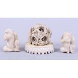 An early 20th century carved ivory concentric ball and stand, and two carved ivory monkeys