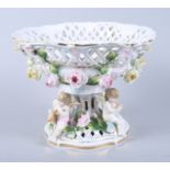 A Continental porcelain table centre with cherub and flower decoration, 10" dia (small chips)