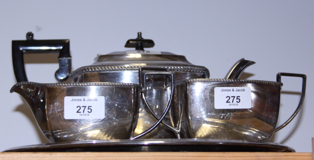 A silver plated three-piece tea set and a circular tray