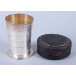A late Victorian silver collapsible travelling beaker, engraved initials, in a leather container,