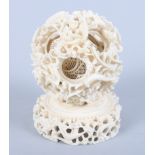 A 19th century Chinese carved ivory concentric ball together with an ivory stand