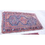 A Qashqai rug with three bird and flower medallions and geometric border in shades of blue red,