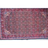 A Herati rug with all-over design in shades of red, blue, black and natural, 91" x 55" approx