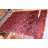 A Bokhara rug with eighteen octagonal guls on a plumb ground, triple bordered in traditional shades,