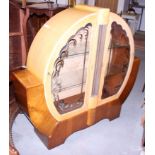 An Art Deco burr maple and walnut circular display cabinet enclosed two panelled doors, on shaped