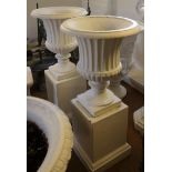 A pair of cast iron fluted campagna vases, on cast iron square bases, 35" high overall