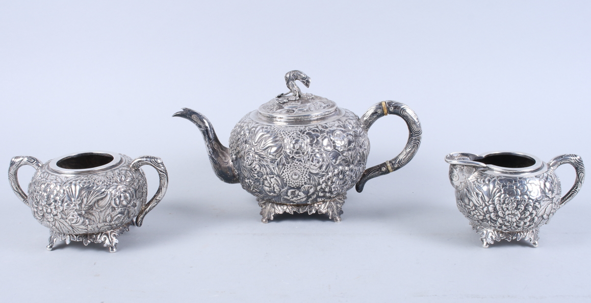 An early 20th century Chinese silver three-piece teaset, by Wang Hing, with embossed all-over floral