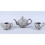 An early 20th century Chinese silver three-piece teaset, by Wang Hing, with embossed all-over floral