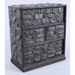 An early 20th century Japanese oak miniature chest of four drawers with applied menuki, 9 1/2" high