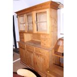 A waxed pine kitchen dresser, the upper section with three glazed doors and three drawers, over