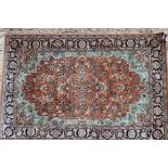 A Persian style silk pile rug with floral design on a rust ground, 45 1/2" x 35 1/2" approx
